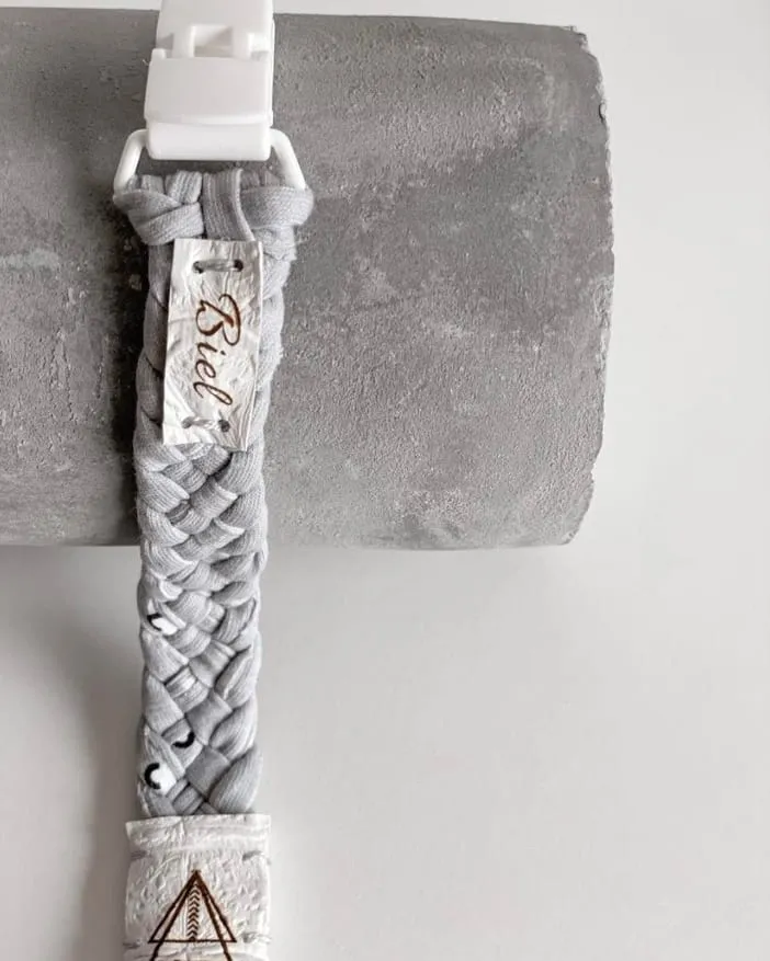 Chupetero trenzado de la colección Grey & White, con el nombre Biel grabado y la etiqueta de marca